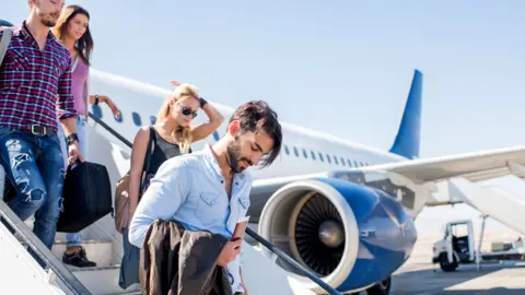 Getty Images Youngsters boarding a plane