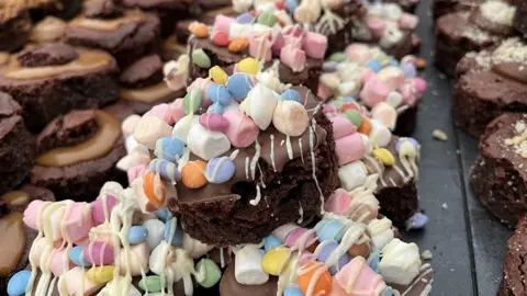 A close up of chocolate brownies topped with marshmallows and sweets