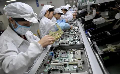 Getty Images Chinese workers assemble electronic components at Foxconn's factory in Shenzhen