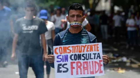 AFP An opposition activist holds a sign reading "Constituent (assembly) Without Referendum is Fraud" as he demonstrates against President Nicolas Maduro"s government in Caracas, on June 5, 2017.