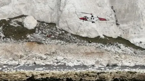 Pete Abel / RNLI A helicopter reaches the injured man