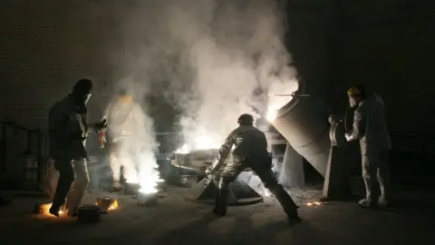 Getty Images Men work inside a uranium conversion facility outside Isfahan (30 March 2005)