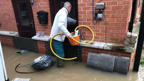 Derek Lown trying to salvage his house after the latest flooding in January