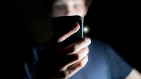 Getty Images A boy on the phone in the dark