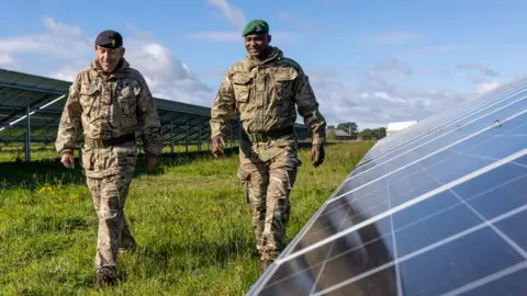 British Army Soldiers walk through a solar farm at the Defence School of Transport (DST) in Leconfield