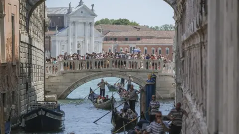 Getty Images Gondolas slowly pass under the Bridge of Sighs near St. Mark's Square due to too much traffic in Venice, August 2023