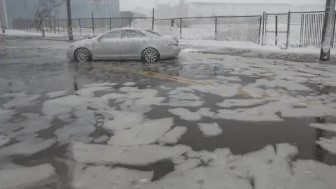 EPA A car is abandoned amid flooding in Massachusetts as a result of a winter storm, 4 January 2018