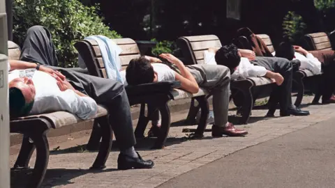 Getty Images Businessmen napping in Tokyo