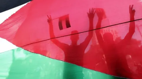 EPA Palestinians celebrate in Gaza City after the reconciliation deal between Fatah and Hamas was announced in Cairo. Photo: 12 October 2017