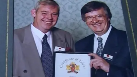 Thomas Brown being presented with his Certificate of Valour from the Post Office