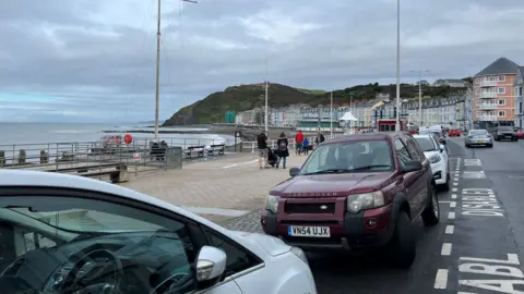 BBC cars parked alongside the promenade in Aberystwyth