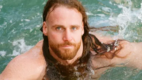 Anthony Mullally swims in the sea off the Cornish coast