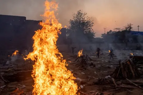 Danish Siddiqui / Reuters Funeral pyres burn in a crematorium in New Delhi, India