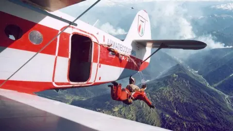 EPA A member of staff of Russia's forest protection is parachuted from a plane in Krasnoyarsk region, Russia. Photo: 1 August 2019