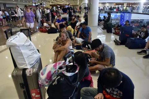 AFP/Getty Images Passengers gather at the Gusti Ngurah Rai International airport in Denpasar, Bali on 27 November 2017, after flights were cancelled due to the threat of an eruption by the Mount Agung volcano.