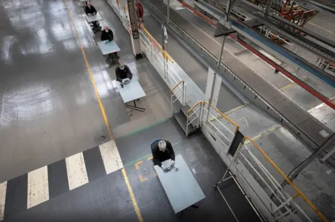 Colin McPherson Aerial view of workers taking break on separate tables