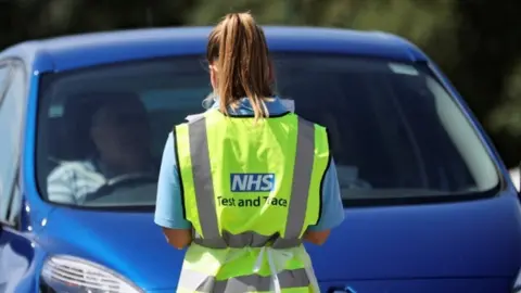 Reuters A person with an NHS track and trace jacket on