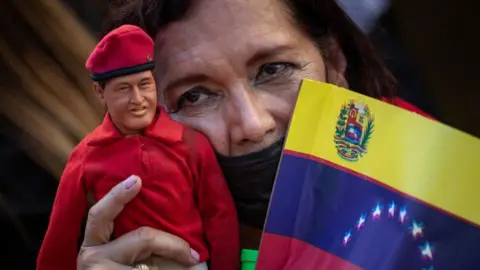 EPA A woman carries a doll of late former president Hugo Chavez during a march in support of the government of Nicolas Maduro in Caracas, Venezuela, 23 January 2024.