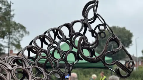 The head of the horse sculpture made using horseshoes