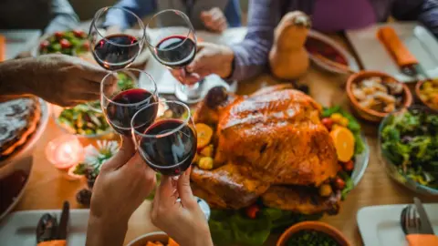 Getty Images Group of people toasting with wine during Christmas