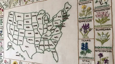 Shannon Downey An image of Rita's quilt showing a map of the US and embroidered representations of each state around the outside.