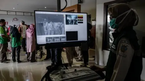 Getty Images People have been thermally scanned when leaving Wuhan, and arriving at their destination. This picture was taken in Indonesia on Thursday