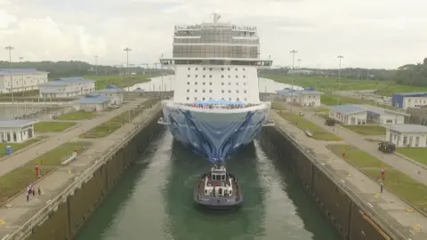 Panama Canal Authority A ship being guided through the Panama Canal