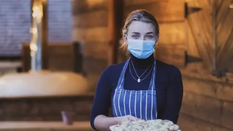 Waitress holding garlic bread