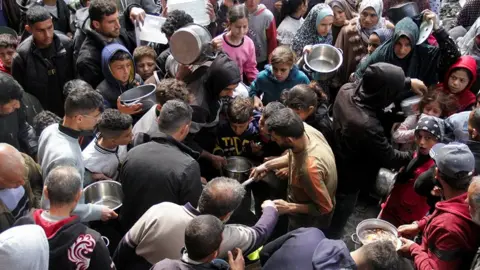 Reuters Palestinians gather to receive free food as Gaza residents face crisis levels of hunger, during the holy month of Ramadan, amid the ongoing conflict between Israel and Hamas, in Jabalia in the northern Gaza Strip March 19, 2024.