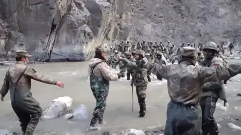 This video frame grab taken from footage recorded in mid-June 2020 and released by China Central Television (CCTV) on February 20, 2021 shows Chinese (foreground) and Indian soldiers (R, background) during an incident where troops from both countries clashed