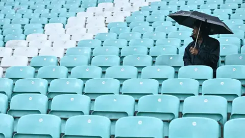 AFP A fan sits under an umbrella as the rain falls down while they game didn't start yet due to the weather condition on day 1 of the third Test match between England and South Africa at the Oval, in London, on September 8, 2022.