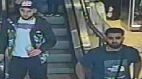 West Midlands Police Two men pictured in a CCTV image issued by police over a hit-and-run crash