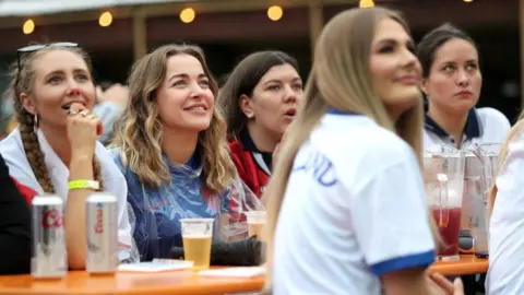 PA Media England fans watching the game at an outside pub