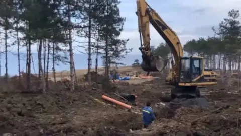 Vasil Gurov A digger at work next to a beach