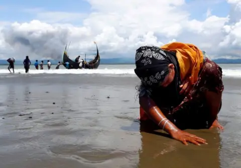 Reuters An exhausted Rohingya refugee woman touches the shore after crossing the Bangladesh-Myanmar border by boat through the Bay of Bengal, in Shah Porir Dwip, Bangladesh September 11, 2017.