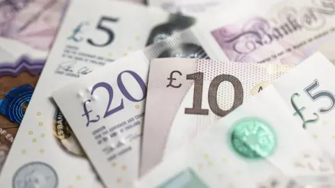 Close up of £20, £10 and £5 notes seen on top of each other