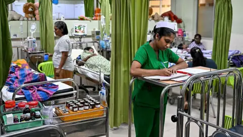 A ward at the District General Hospital in Sri Lanka's Negombo city where dengue patients are getting treated. A nurse in green is seen taking notes in the foreground