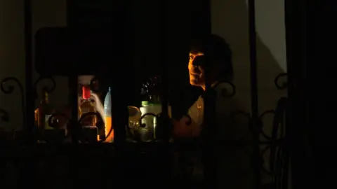 People sitting at table in the dark, with drinks