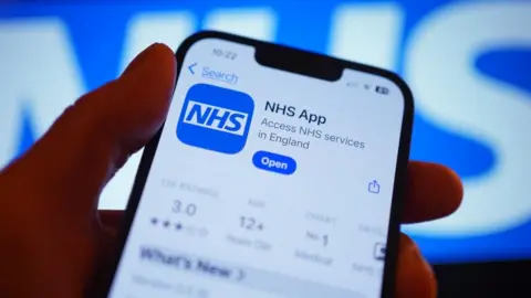 A hand holds a smartphone displaying the NHS app after it has been downloaded.