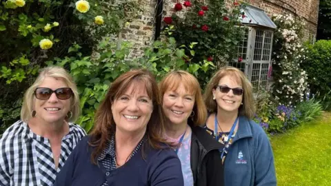 JACQUELINE LEMAR Four women smiling stood outside a manor house