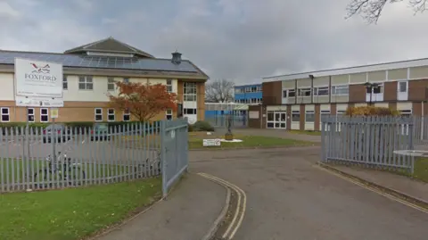 Google Street view of Foxford School & Community Arts College. The brick two-storey building is surrounded by a grey metal fence