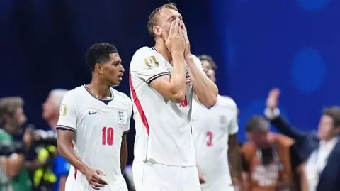 Dan Burn holds his face
