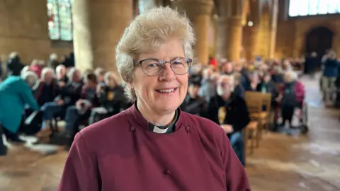 The Very Reverend Nicola Sullivan, Dean of Southwell, smiling at the camera while inside the minster