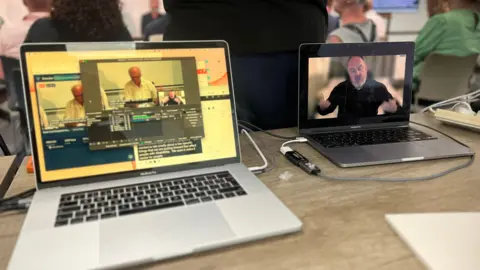 Emma Baugh/BBC Two laptops with a BSL interpreter on one and the debate on the other