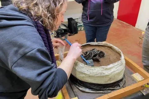 Guard Archaeology Rachel Buckley examining the hoard