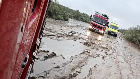 Paul McNulty A fire engine and ambulance stuck in thick mud