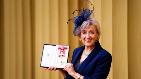 Dame Andrea Leadsom, wearing a blue blazer and fascinator hat, after being made a Dame Commander of the British Empire for services to politics by the Prince of Wales during an investiture ceremony at Buckingham Palace, London