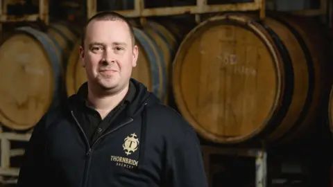 Thornbridge Brewery Dom Driscoll wearing a black coat inside Thornbridge Brewery