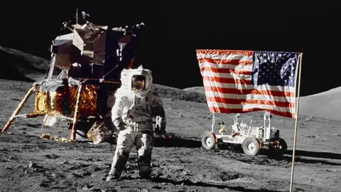 Getty Images Harrison H Schmitt, pilot of the lunar module, stands on the lunar surface near the United States flag during NASA's final lunar landing mission in the Apollo series, on 13 December 1972.