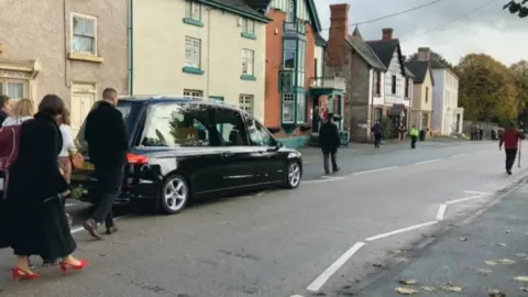 Mourners following a hearse